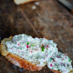 Tartine de fromage frais aux radis sur planche en bois