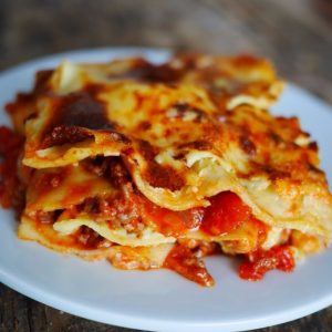 Lasagnes à la bolognaise appétissantes sur assiette blanche.