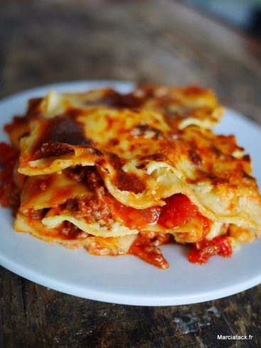 Lasagnes à la bolognaise appétissantes sur assiette blanche.
