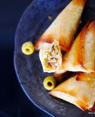 Briouats croustillants aux olives sur assiette noire