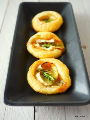 Mini-tartes feuilletées au chèvre et romarin sur plat noir.