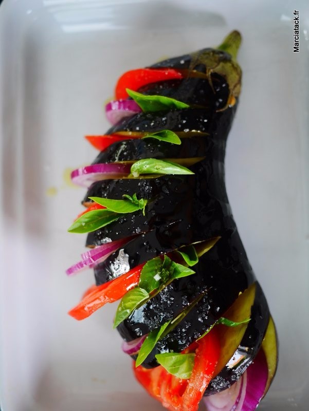 Aubergine farcie aux légumes colorés et basilic frais.