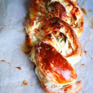 Brioche tressée au fromage, appétissante et dorée.