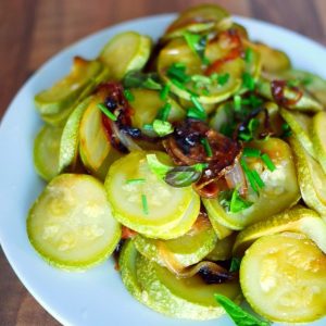 Plat de courgettes sautées avec oignons et ciboulette.