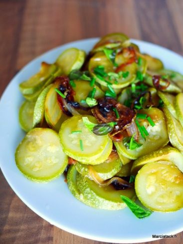 Plat de courgettes sautées avec oignons et ciboulette.