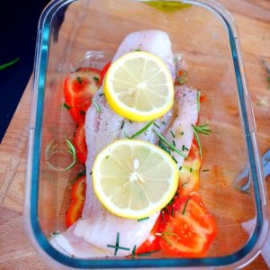 Poisson cru, tomates, citron en préparation dans un plat
