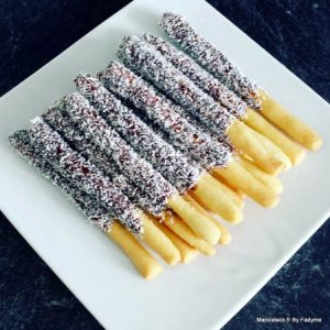 Mikados chocolat coco sur assiette blanche.