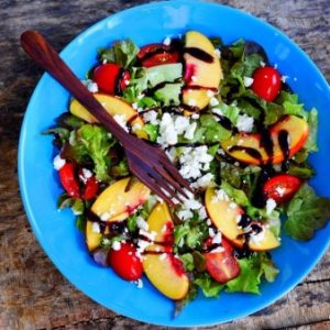 Salade de pêches, tomates et feta sur assiette bleue