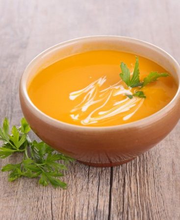 Bol de soupe de potiron avec crème et persil.