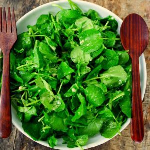 Salade de cresson fraîche avec fourchette et cuillère en bois