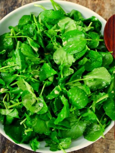 Salade de cresson fraîche avec fourchette et cuillère en bois
