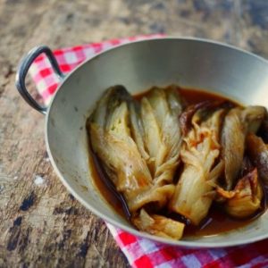 Endives braisées dans une poêle sur une table bois