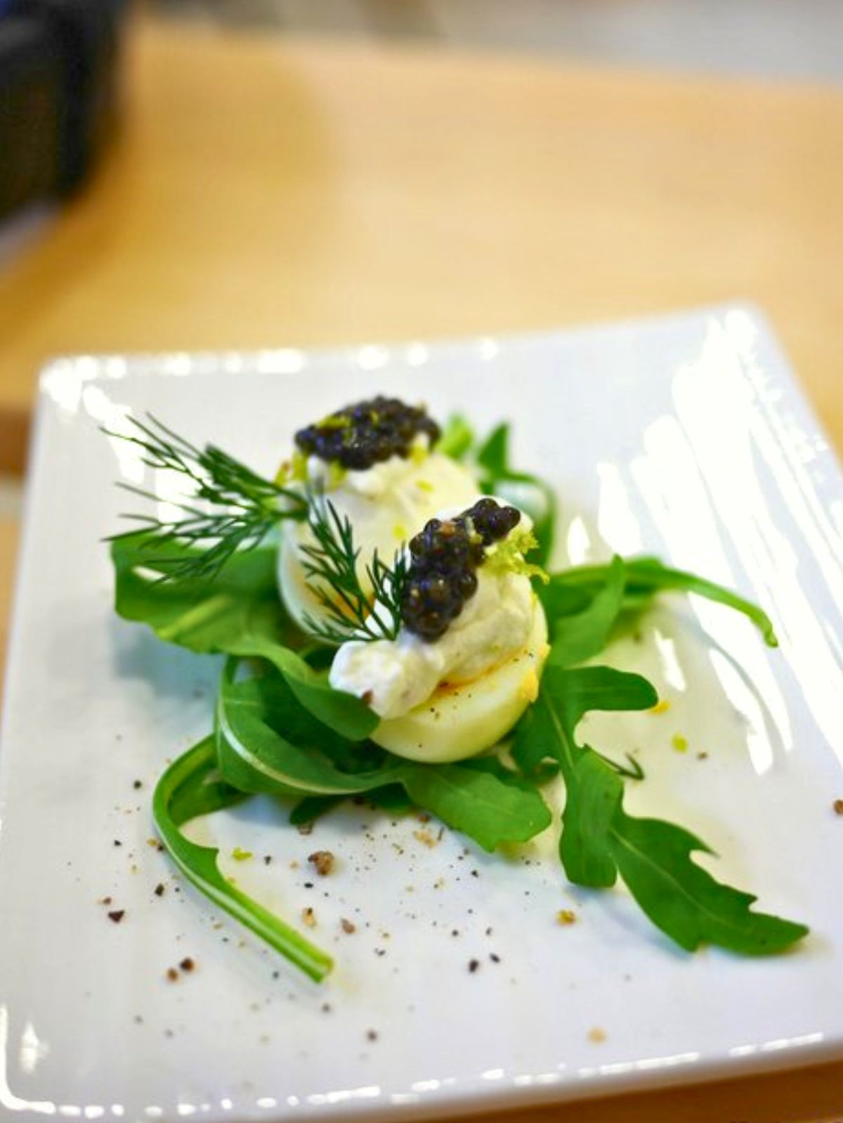 Oeufs farcis au caviar, roquette et aneth.