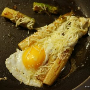 Oeuf au plat avec asperges et fromage râpé.