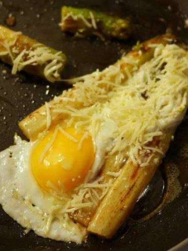 Oeuf au plat avec asperges et fromage râpé.