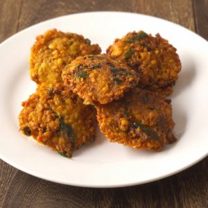 Vadas indiens frits sur une assiette blanche.