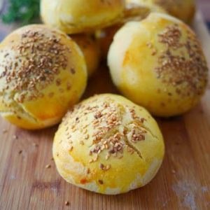 Brioches dorées aux graines de sésame sur une planche en bois