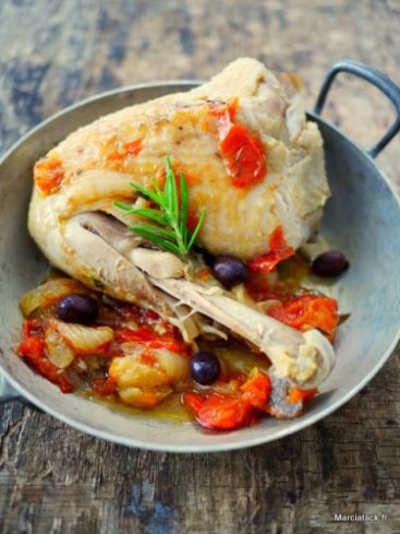 Poulet rôti aux tomates et olives dans une poêle.