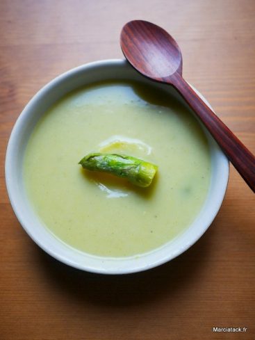 Bol de crème d'asperges avec cuillère en bois.