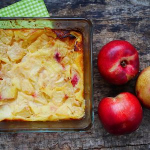 Clafoutis aux nectarines et fruits sur table boisée
