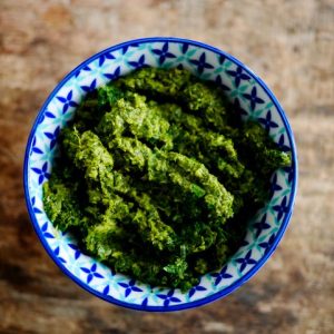 Bol de pesto vert sur fond bois