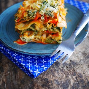 Lasagnes végétariennes sur assiette bleue avec fourchette.