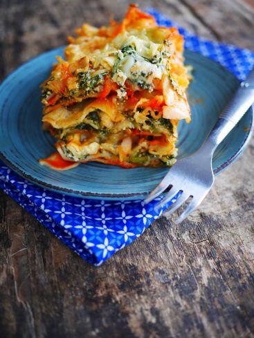Lasagnes végétariennes sur assiette bleue avec fourchette.