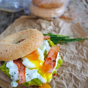 Bagel garni: avocat, œuf poché, bacon, ciboulette.