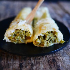 Rouleaux farcis aux légumes verts sur assiette noire.