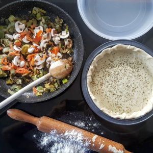 Préparation d'une tarte aux légumes et saumon.
