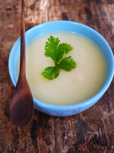 Soupe crèmeuse au bol bleu, coriandre et cuillère bois