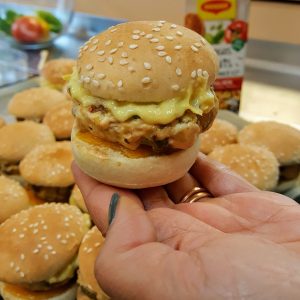 Mini burger fait maison tenu dans la main