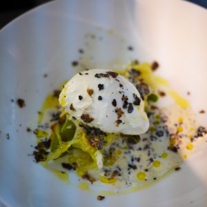Oeuf poché, truffes, sauce crème dans une assiette