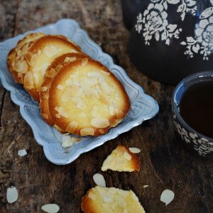 Thé, tuiles aux amandes sur table en bois