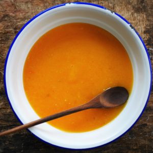 Bol de soupe orange avec cuillère en bois