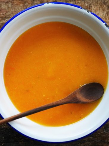 Bol de soupe orange avec cuillère en bois