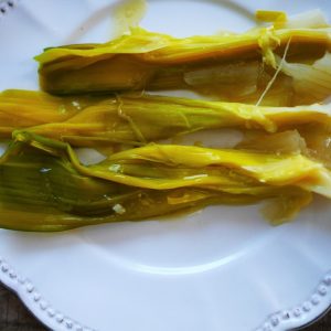 Poireaux braisés sur assiette blanche