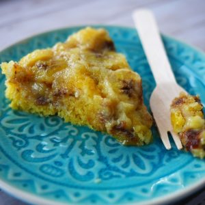 Gâteau renversé à la banane sur assiette bleue.
