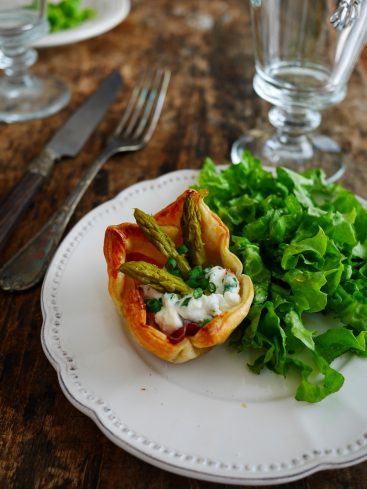 Tartelette asperges, salade verte, sur assiette blanche.