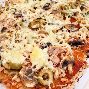 Pizza maison : thon, champignons, olives et fromage.