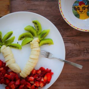 Assiette de fruits : palmiers kiwis, bananes, fraises.