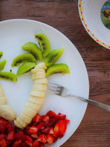 Assiette de fruits : palmiers kiwis, bananes, fraises.