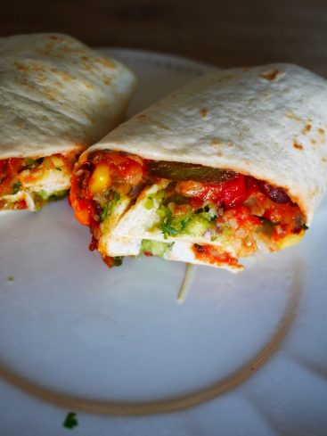 Burrito coupé en deux, garniture colorée visible.