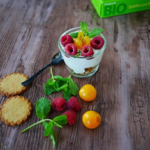 Dessert bio avec framboises, physalis, biscuits et menthe.