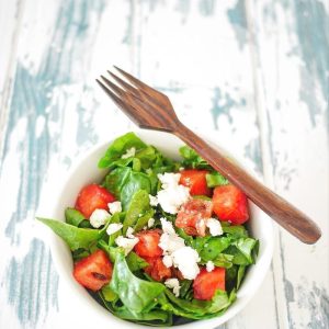 Salade d'épinards, pastèque et feta avec fourchette en bois.