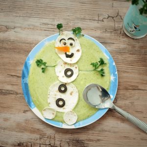 Bonhomme de neige créatif fait de nourriture dans une assiette.