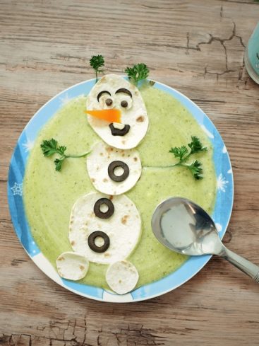 Bonhomme de neige créatif fait de nourriture dans une assiette.
