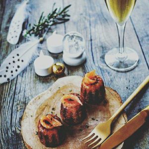 Canelés au saumon, verre de vin blanc, décoration festive.