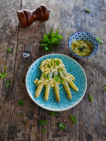 Asperges blanches, œuf mimosa, menthe fraîche sur assiette bleue.