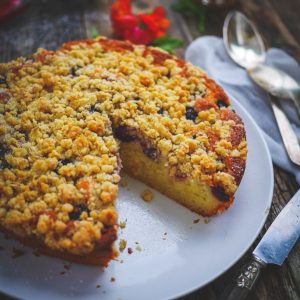 Gâteau crumble aux fruits rouges sur table en bois